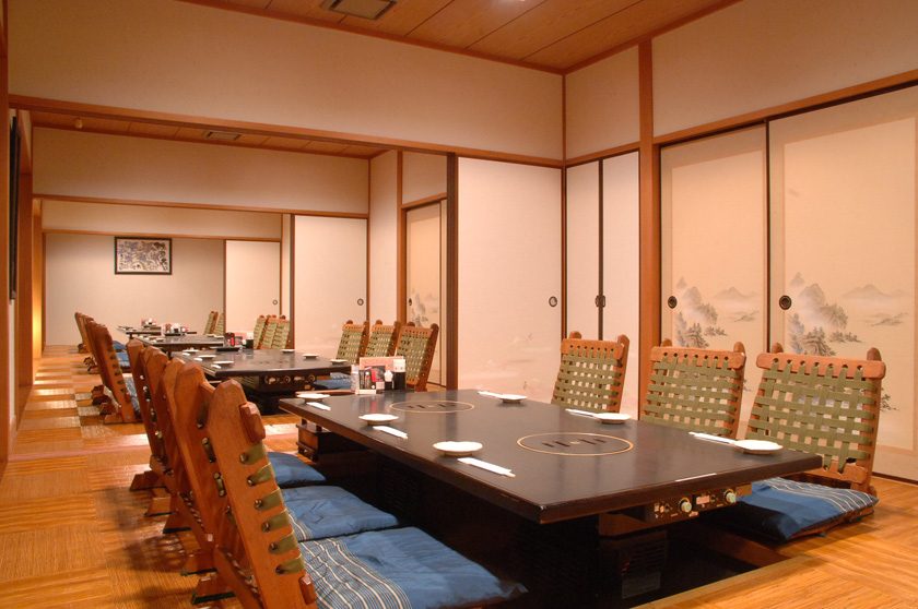 夕方の街になじむ焼肉店の外観と入口まわりのあたたかな灯り