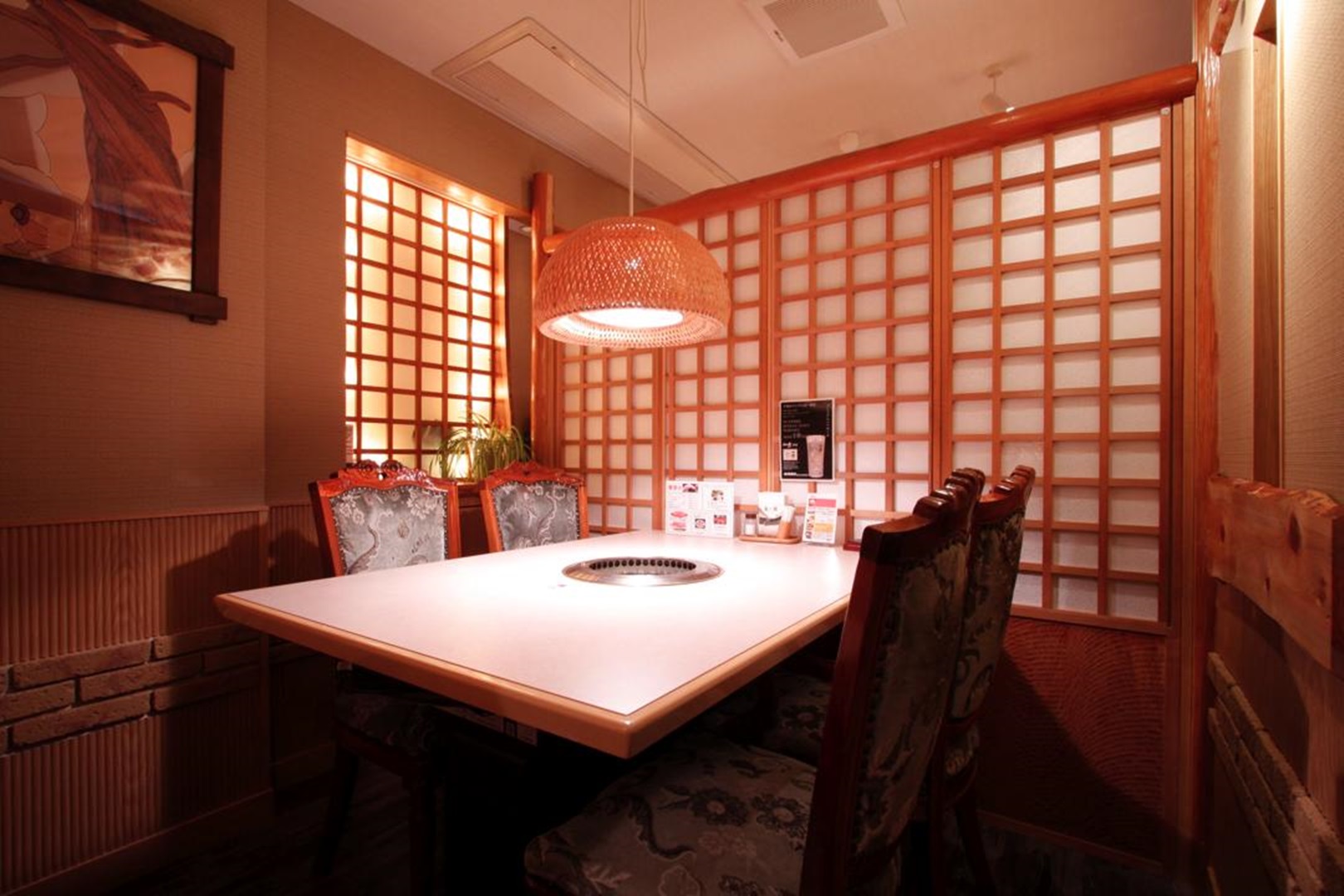 木の質感がやさしく伝わる落ち着いた焼肉店の個室空間とテーブル席