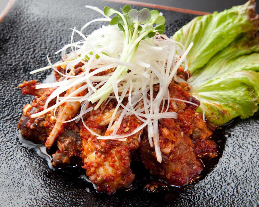 新宿の街に面した焼肉店の入口とあたたかな灯りが見える外観写真
