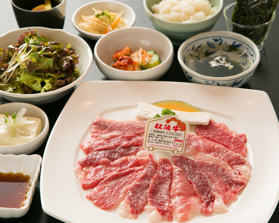 白い湯気がやわらかく立ちのぼる石焼ビビンバと韓国家庭料理の小鉢が並ぶ食卓風景