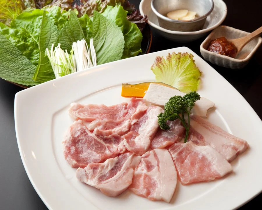 東京Xの厚切り肉と新鮮な野菜が木の天板に整えられた上質な盛り付け